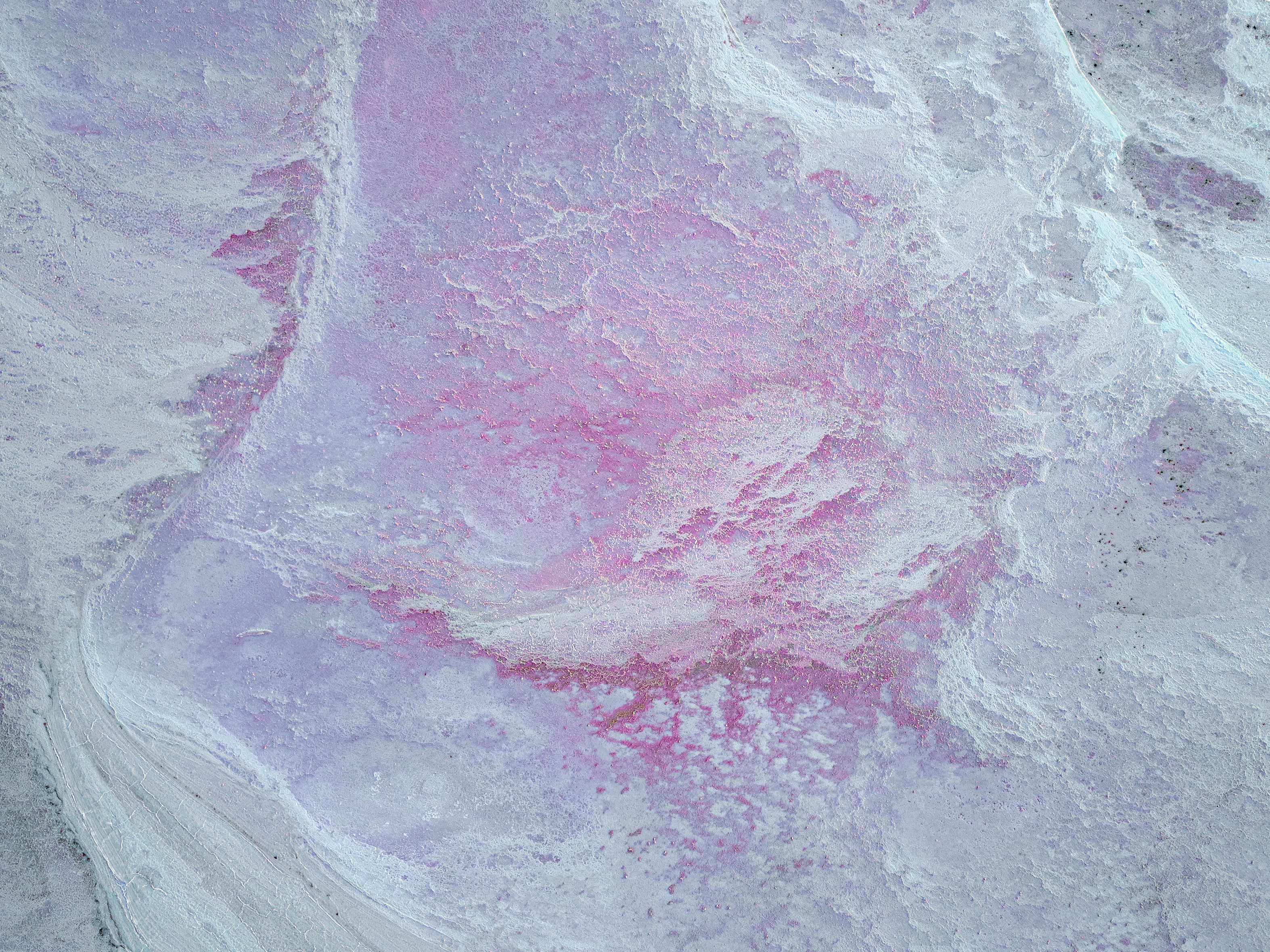 Aerial view of pale pink and lavender salt flat textures
