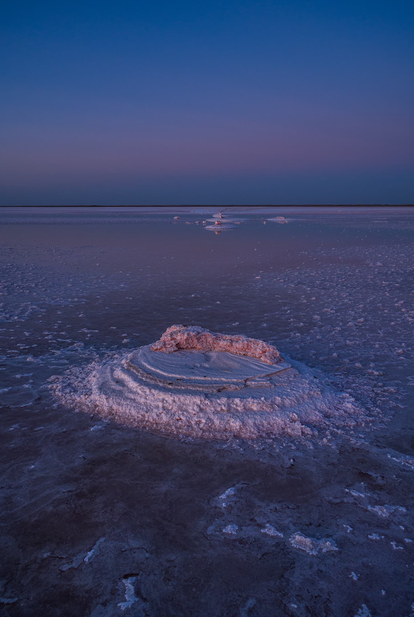 Salt formations stacked at the edge of a lake