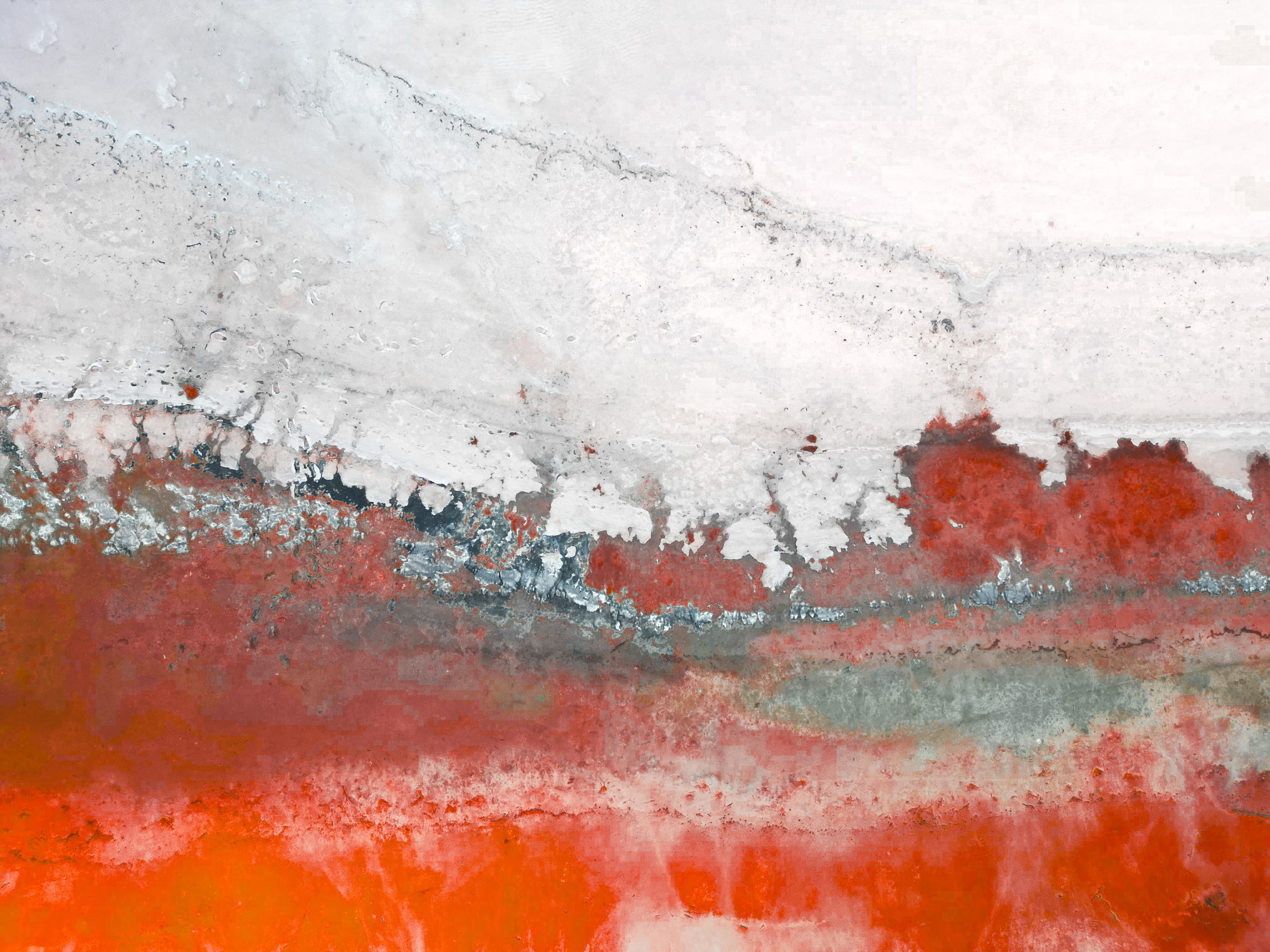Crimson salt flat with teal and grey banded layers beneath