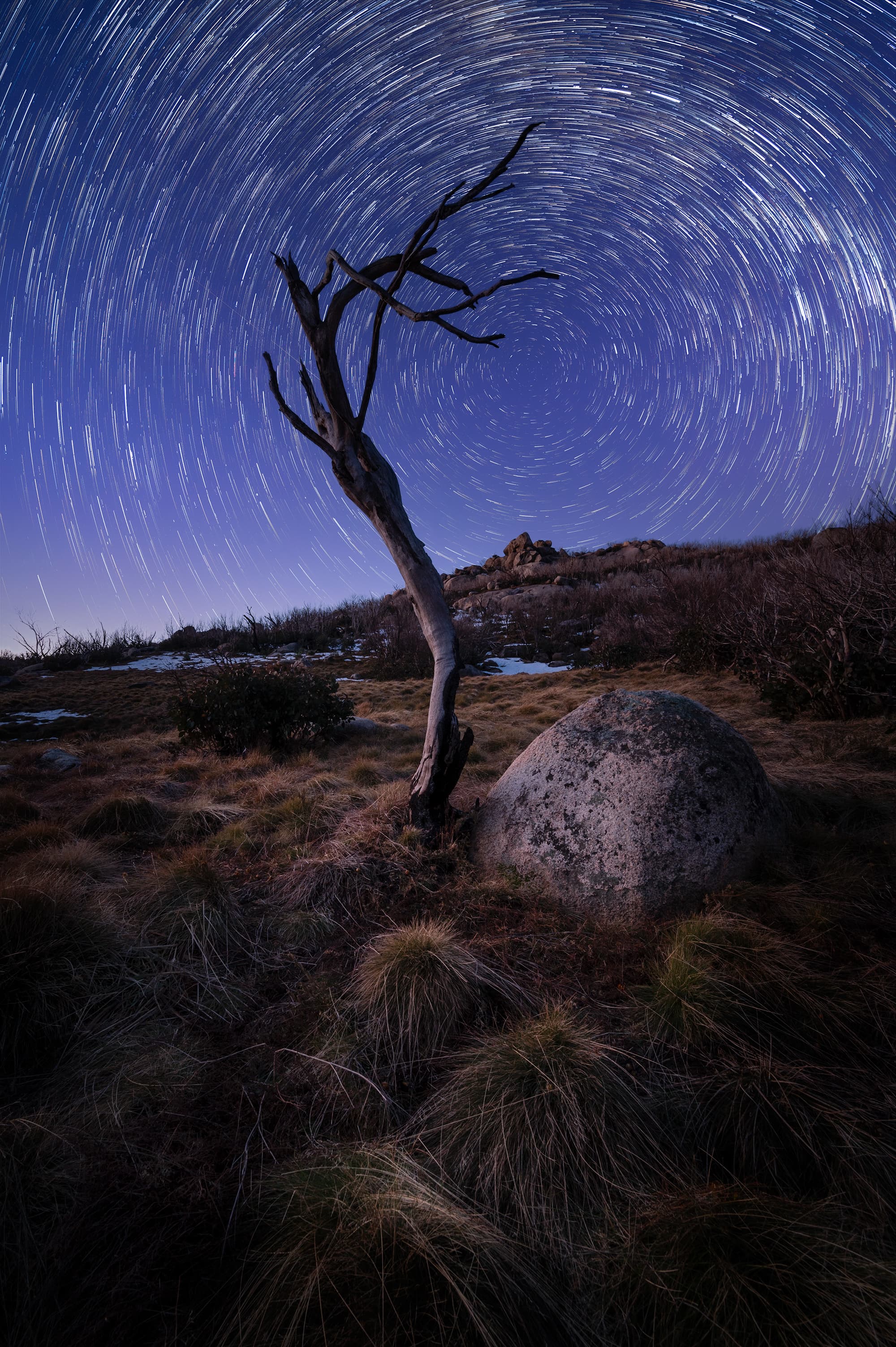 Star trail spiral above alpine landscape