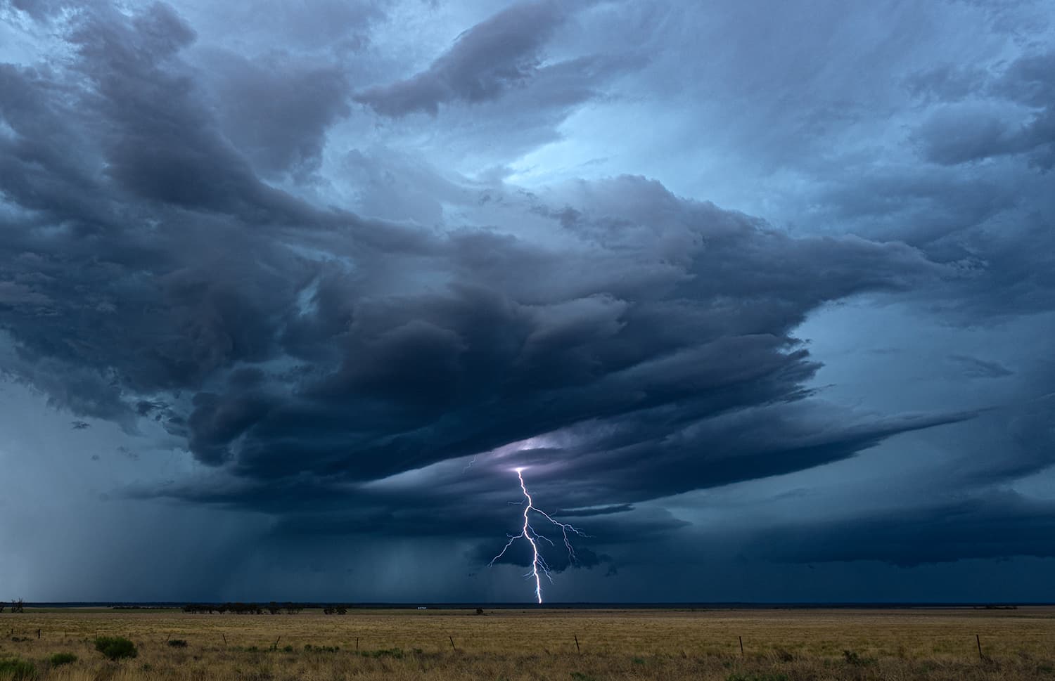 Supercell structure with lightning bolt cutting through the storm