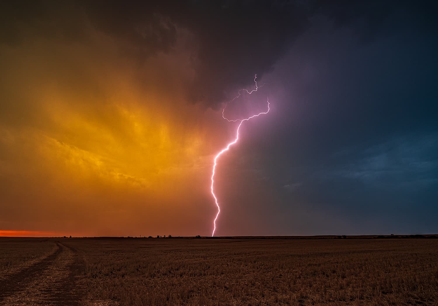Lightning bolt striking against a vivid sunset sky